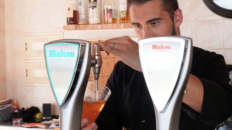 Camarero en el bar del cámping echando una cerveza